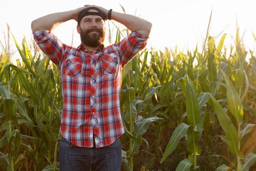 Man with hands behind head in field