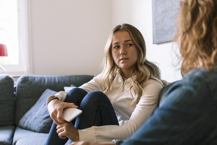 Woman on couch sharing breast cancer diagnosis