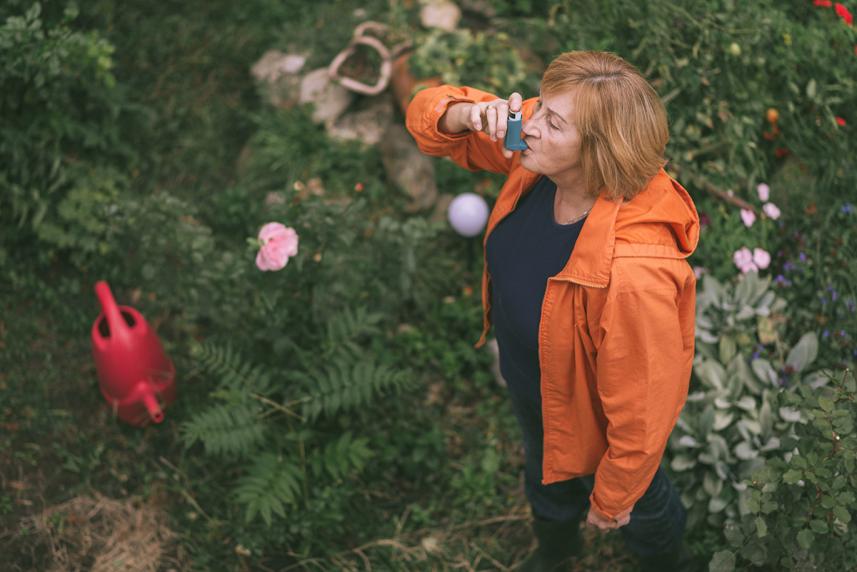 Woman in garden with inhaler