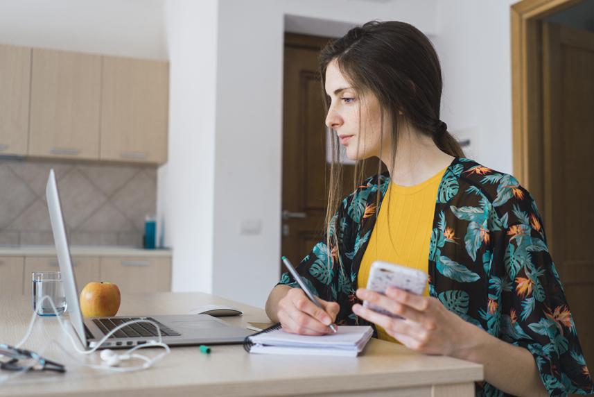 Woman with laptop taking notes