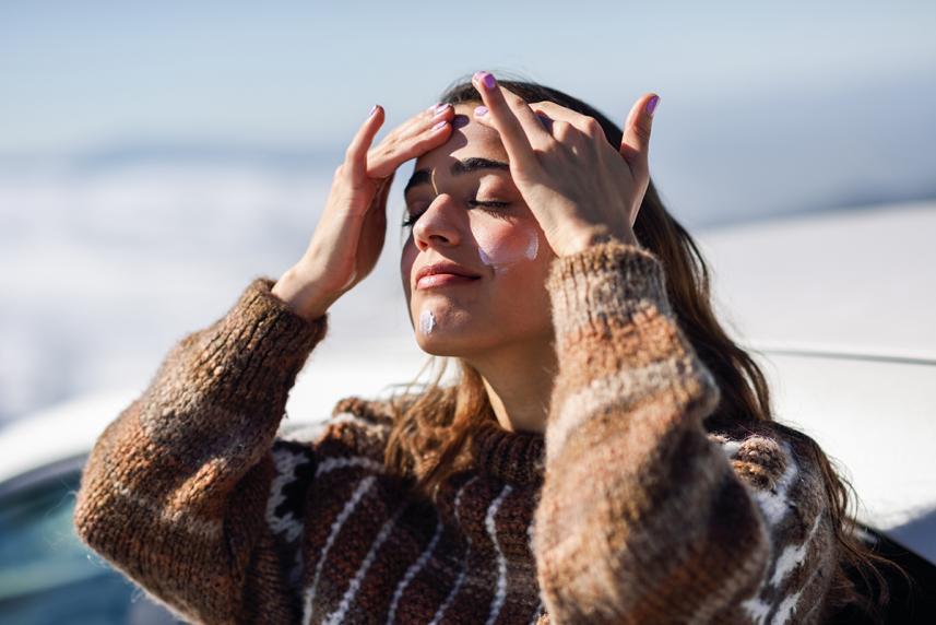 Woman applying sunscreen to face