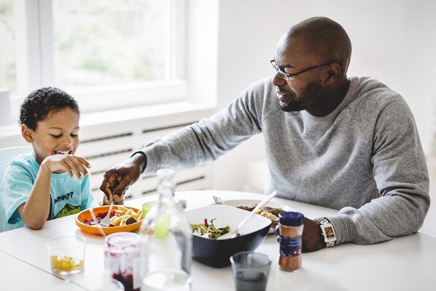 Father and son eating at table