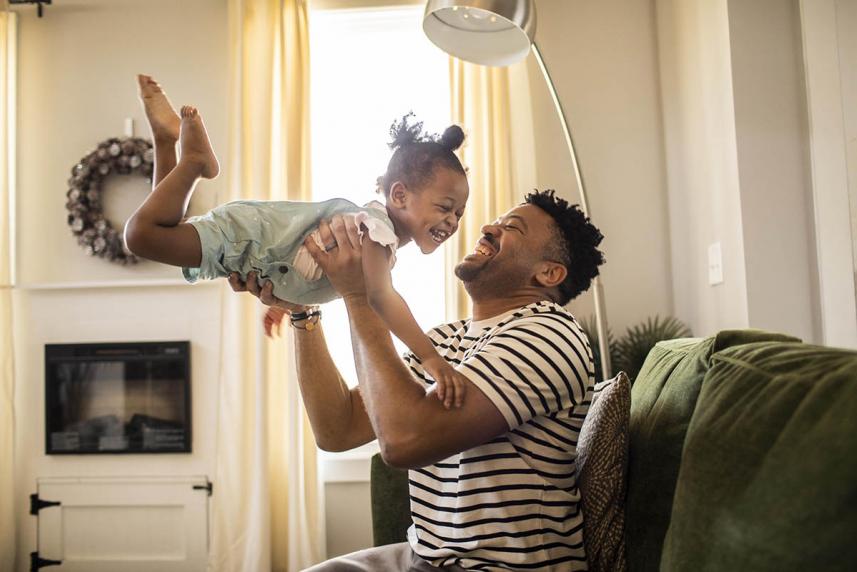 Smiling father lifting up smiling toddler