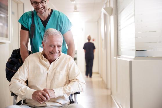 Man in hospital being pushed in wheelchair